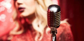 Person singing with vintage microphone in bright setting