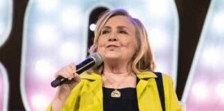 Person speaking into microphone wearing yellow jacket