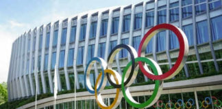 Building with Olympic rings and flags outside