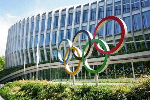 Building with Olympic rings and flags outside