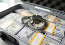 Briefcase with handcuffs and stacks of US dollars
