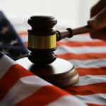 New Jersey Defies Trump–Federal Lawsuit Hits Gavel and hand on American flag.