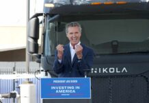 A speaker passionately addressing an audience in front of an electric truck