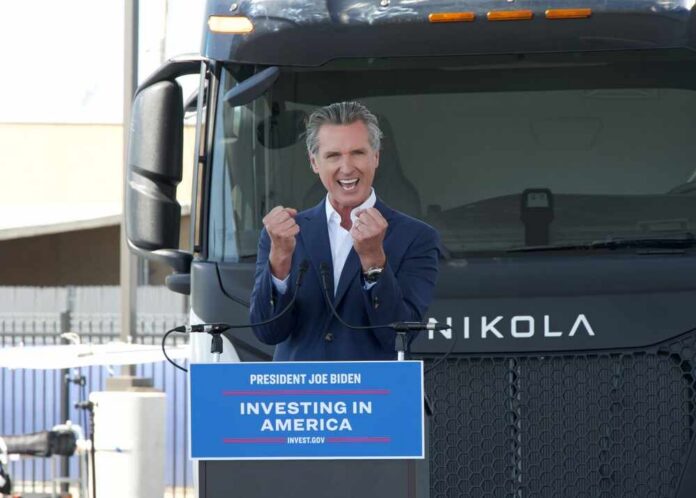 A speaker passionately addressing an audience in front of an electric truck