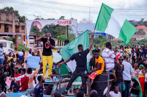 Group of people holding Nigerian flags during demonstration.