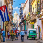 Caught on Radar: Russian Oil Heads to Cuba Colorful street scene with Cuban flag and people.