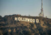 Hollywood sign with communication tower on hillside.