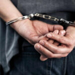 Person handcuffed with hands behind back.