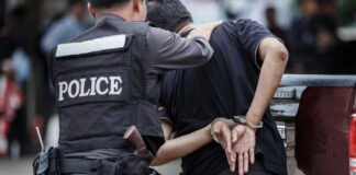 Police officer arresting a suspect in handcuffs in an urban environment