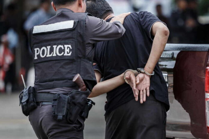Police officer arresting a suspect in handcuffs in an urban environment