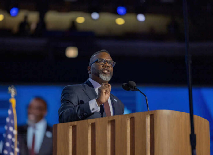 A man speaking at a podium with microphones