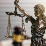 Blindfolded lady justice statue with scales and gavel
