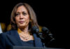 RIOTS ROCK Los Angeles—Harris Defends Attackers Woman speaking at a podium in professional attire