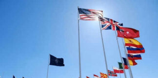 Flags of multiple countries against blue sky