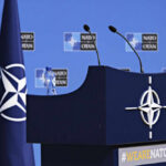Russian Spy Planes Busted–NATO Strikes Fast! NATO podium with flags and microphones.
