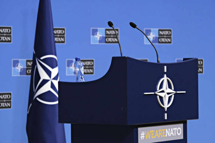 nato283194314 NATO podium with flags and microphones.