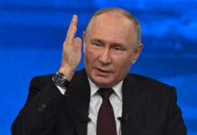 Man in suit gesturing with hand during speech