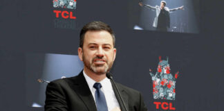 A man in a suit speaking at a podium during a public event