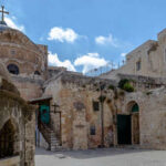 Historic religious site in Jerusalem with stone buildings and a cross