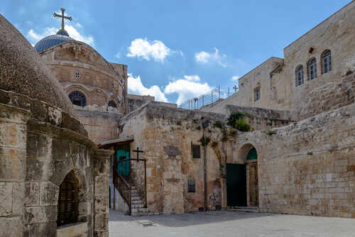 shutterstock_1958179525.jpg Historic religious site in Jerusalem with stone buildings and a cross