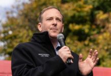A man speaking into a microphone at an outdoor event