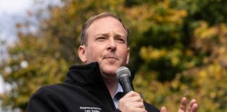 A man speaking into a microphone at an outdoor event