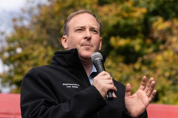 shutterstock_2220823823.jpg A man speaking into a microphone at an outdoor event