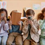 Online Safety or Surveillance? The Hidden Battle Four children sitting together, each focused on their electronic devices