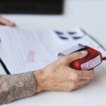 Dramatic Visa Rule Shift: Students Face Uncertainty A hand holding a red stamp labeled 'REJECTED' over a document