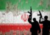 Silhouettes of armed figures in front of a distressed Iranian flag