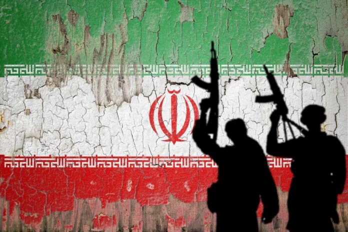 Silhouettes of armed figures in front of a distressed Iranian flag