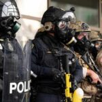 ICE Agents Face ARREST Threat at Major Airport Police officers in tactical gear and gas masks standing in formation