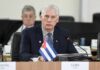 Cuban representative at a political meeting with a flag on the table
