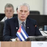 Cuban representative at a political meeting with a flag on the table