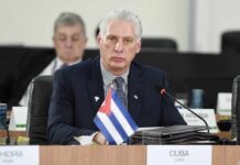 Cuban representative at a political meeting with a flag on the table