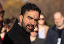 A man speaking passionately to a group of people outdoors