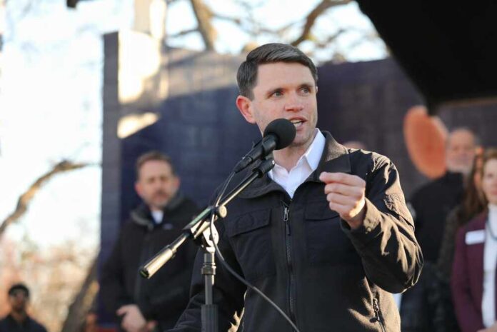shutterstock_2734324469.jpg A speaker addressing an audience at an outdoor event with a microphone