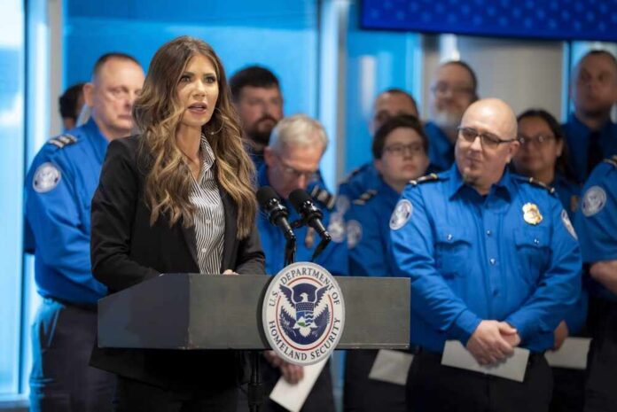 shutterstock_2739624163.jpg A woman speaking at a podium during a press conference with government officials in the background