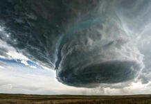 Massive storm cloud over open field sky threatening
