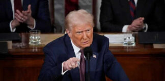 Man in suit speaking at a podium during an event