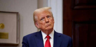 Person in suit and red tie standing indoors