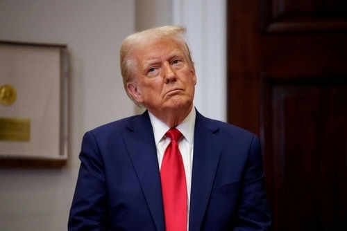 Person in suit and red tie standing indoors