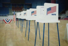 Voting booths lined up in a gymnasium.