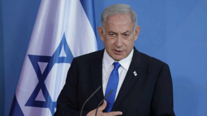 Man speaking in front of Israeli flag backdrop