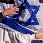 Massive IDF Assault Shakes Hezbollah’s Core People holding an Israeli flag together, showcasing unity and cultural pride