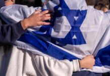 People holding an Israeli flag together, showcasing unity and cultural pride