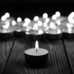 Father’s Rampage: 8 Kids Dead in Horror Massacre Single candle burning among many on wooden surface.
