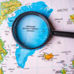 Magnifying glass over map of Greenland and Arctic Ocean