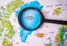 Greenland Confrontation: NATO Allies Push Back Hard Magnifying glass over map of Greenland and Arctic Ocean