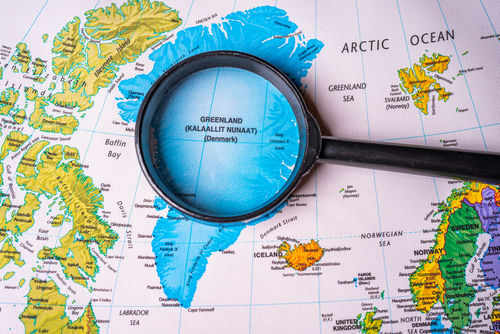 Magnifying glass over map of Greenland and Arctic Ocean